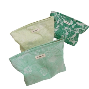 Three green jacquard canvas makeup bags with floral texture and simple wish label