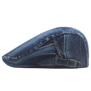 Close-up of vintage washed denim flat cap featuring bronze metal buckle and stripe texture