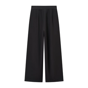 Dettaglio dei pantaloni neri a gamba larga con drappeggio elegante e consistenza setosa