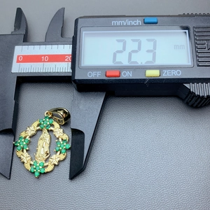 Detailed measurement of Virgin Mary pendant width using digital calipers showing 22.3 mm