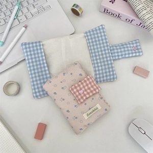 Detailed view of floral and plaid fabric book covers with soft plush textures and cute buttons