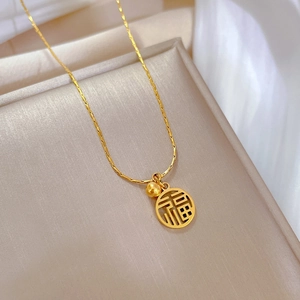 Gros plan du collier en acier titane doré avec pendentif ajouré du caractère Fu