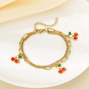 Detailed shot of double-layered 18K gold-plated anklet with red enamel cherry charms
