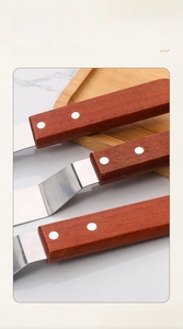 Detail of three stainless steel spatulas with rosewood handles and secure rivet joint