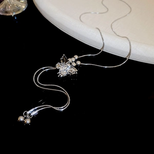 Macro view of silver butterfly pendant with crystals and snake chain details