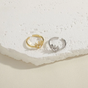 Elegant gold and silver crown rings with sparkling cubic zirconia on a stone base