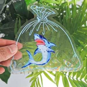Macro detail of holographic rainbow prism shark suncatcher sticker on a sunny background