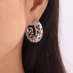 Minimalist silver geometric hollow earrings in artistic coral design worn by a model
