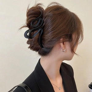 Large matte black 13cm wave shark hair claw clip for women shown in a messy bun hairstyle