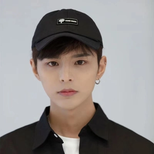 Detailed view of black cotton baseball cap featuring unique 'Hand Made' patch on forehead