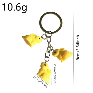 Three yellow resin rabbit keychains with textured fur details and golden metal rings