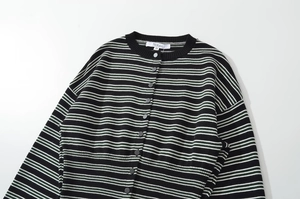 Detail of striped knit cardigan collar with grey buttons and woven fabric texture