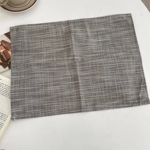 Detail of gray and white striped linen placemat showing the fine woven texture and fabric edge