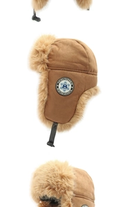 Detail of khaki earflap hat showing the thick faux fur lining and embroidered winter badge