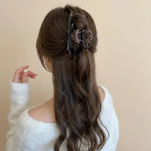Leopard print hair claw clip with black bow detail on a female model wearing white sweater