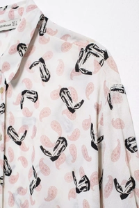 Close-up of shirt collar with vintage cowboy boot and pink paisley print patterns