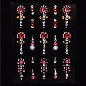 Colorful floral face gems and pearls set for makeup decoration on black background