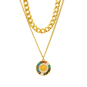 Dettaglio macro della collana d'oro a tre strati con pendente sole smaltato e strass