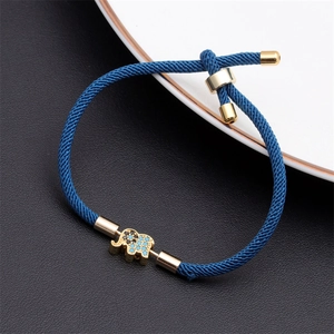 Detail of blue adjustable rope bracelet featuring a golden elephant charm and metal buckle