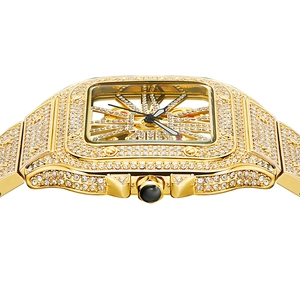 Macro shot of gold square watch head featuring iced-out diamonds and hollow dial details