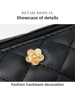 Macro shot of black quilted leather cylinder bag with gold camellia hardware detail