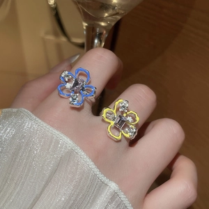 Dettaglio dell'anello a fiore in smalto con gemma viola e pietre di zircone bianco