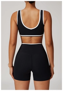 Vue arrière d'un ensemble brassière et short de sport noir avec liseré blanc contrasté
