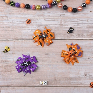 Three-layer Halloween bow hair clips in orange and purple ribbon on a wooden background