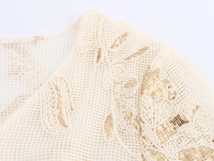 Detail of elegant gold leaf embroidery and sequins on creamy white mesh fabric