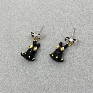3D black enamel bunny earrings with silver bow and yellow crystals on grey background