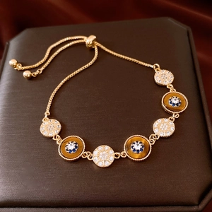 Détail d'un bracelet coulissant plaqué or 18K avec œil de tigre et disques de cristal