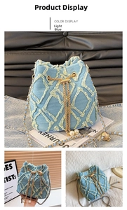 Detailed close-up of light blue denim bucket bag with quilted edges and pearl drawstring