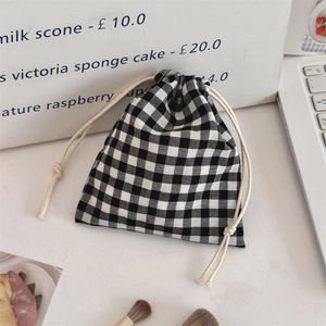 Close-up of a black and white checkered drawstring storage pouch on a desktop setting