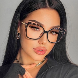 Detail view of stylish square tortoise shell and black frame glasses on a female model