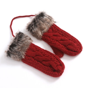 Detail of red knitted mittens with brown faux fur cuffs and connecting string