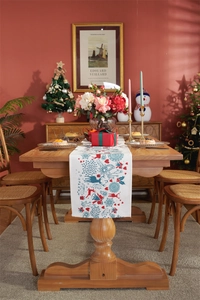 Detail of Christmas table runner with reindeer and snowflake prints on a festive table