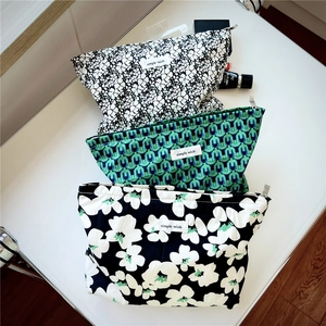 Detailed view of three vintage floral and geometric cotton canvas makeup bags with zippers