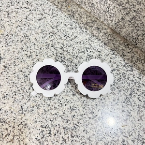 Detail of flower-shaped children's sunglasses showing UV400 protection and CE certification label