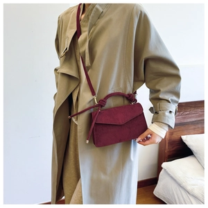 Detail of wine red matte crossbody bag with knotted handle and long shoulder strap