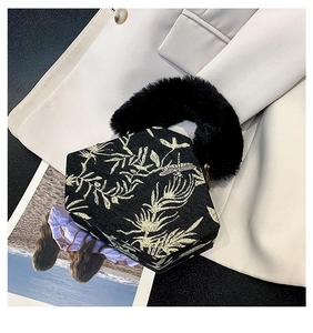 Detail of hexagonal canvas handbag featuring gold leaf embroidery and plush fur handle