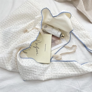 Vue détaillée du sac en toile à pois blancs avec bordure bleue et bretelles nouées