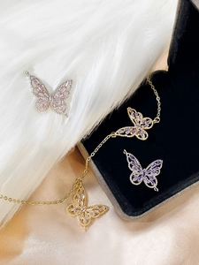 Detailed view of 14k gold plated butterfly charms with pink and purple zircon stones