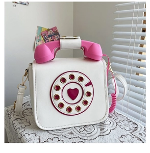 Front view of creative white PU crossbody bag with pink rotary phone design