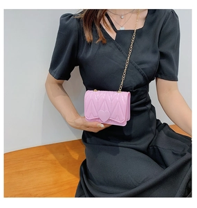 Detail of pink silicone heart crossbody bag with V-shaped texture and gold chain strap