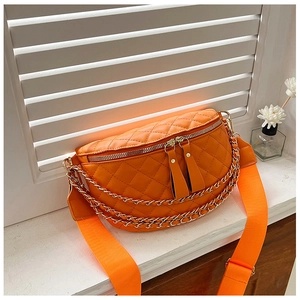 Detail of orange quilted crescent fanny pack with golden chain and adjustable strap
