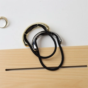 Detail of high-gloss gold and silver metallic hair ties with black elastic bands