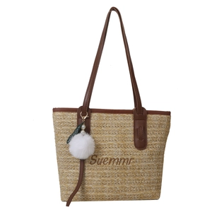 Beige woven straw tote bag with brown leather handles and Suemmr embroidery detailing