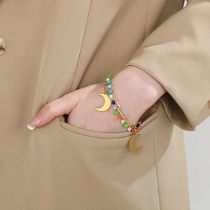 Close-up of double-layer gold crescent moon bracelet with colorful beads on a model