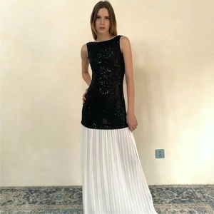 Detail view of backless sleeveless sequin bodice joined with white pleated maxi skirt