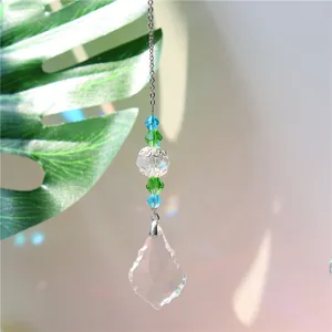 Detailed view of faceted crystal suncatcher with teal beads reflecting rainbow light